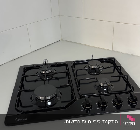 כיריים גז שחורות מותקנות על משטח עבודה במטבח